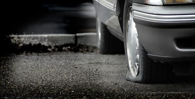 Technician changing a flat tire